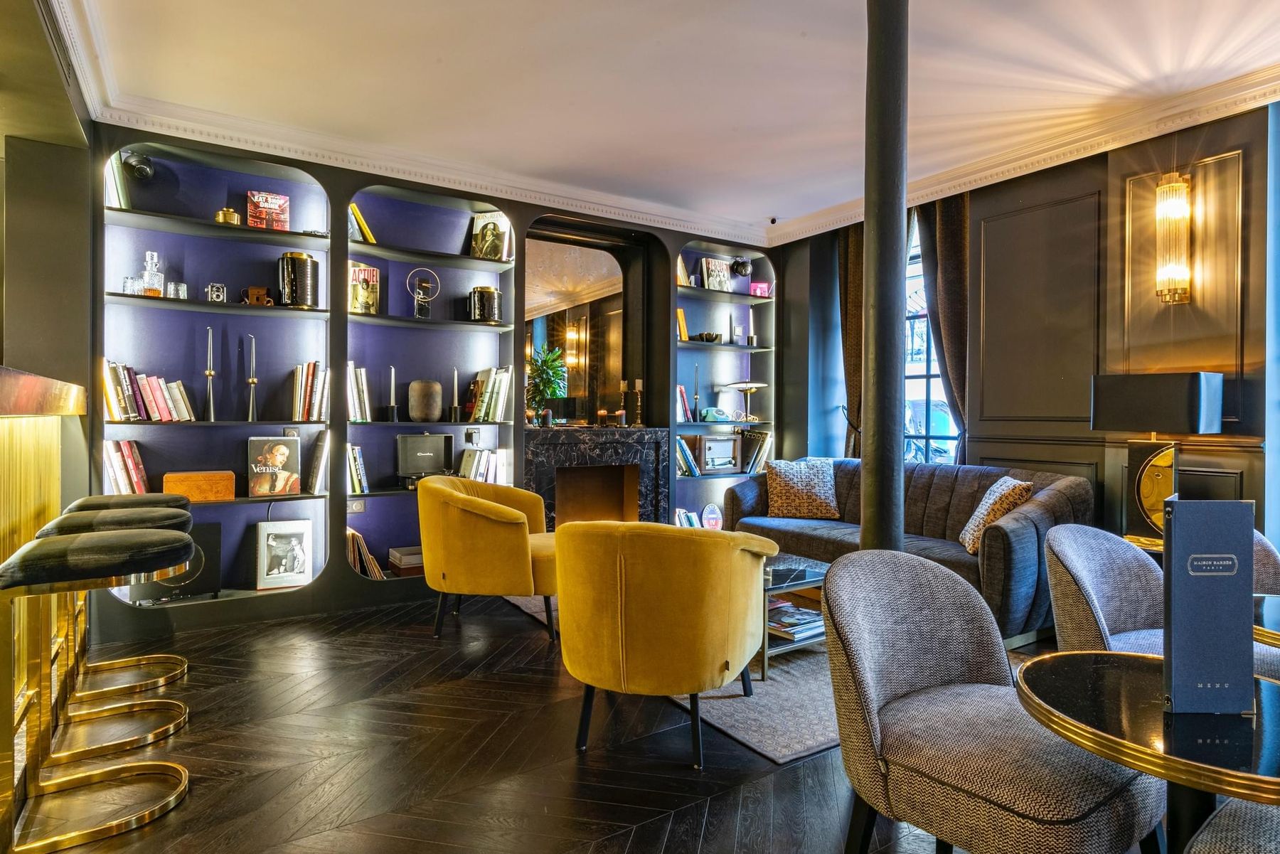 Le salon-bar, fauteuils de velours moutarde et bibliothèques